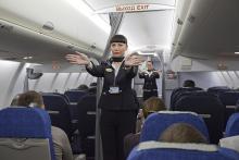 Flight attendants performing a pre-flight safety demonstration on an Aeroflot Sukhoi Superjet
