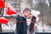 A smiling couple with heart shape baloons